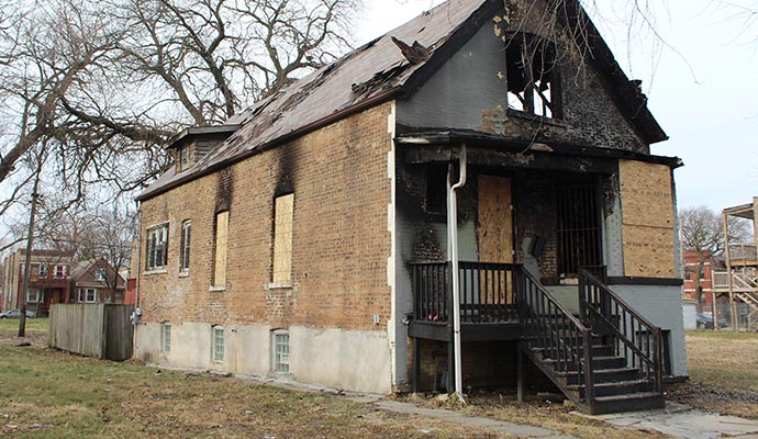 Boarded-up fire damaged house