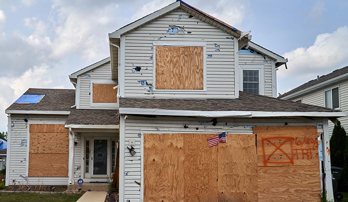 Hail damage boarded-up house