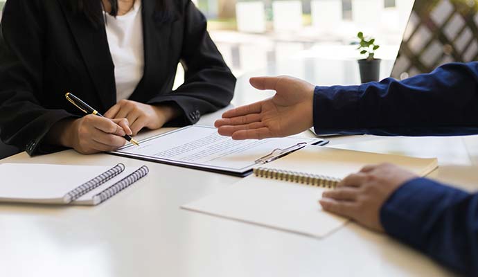 Two people are signing insurance claim documents 