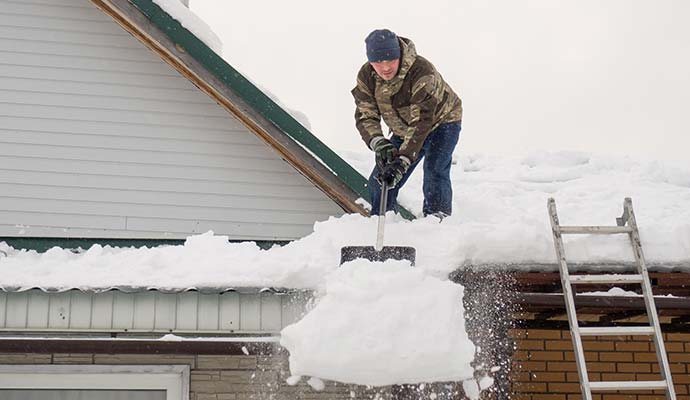 A person is cleaning ice from roof