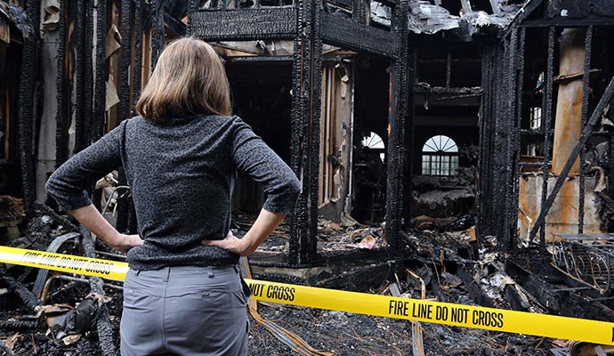 A person is assessing smoke damaged house