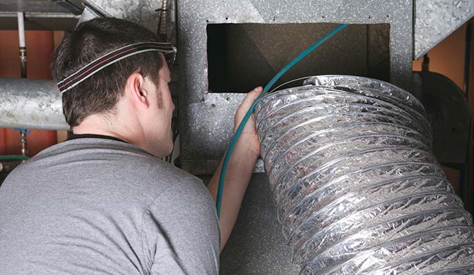Technician inspecting air duct