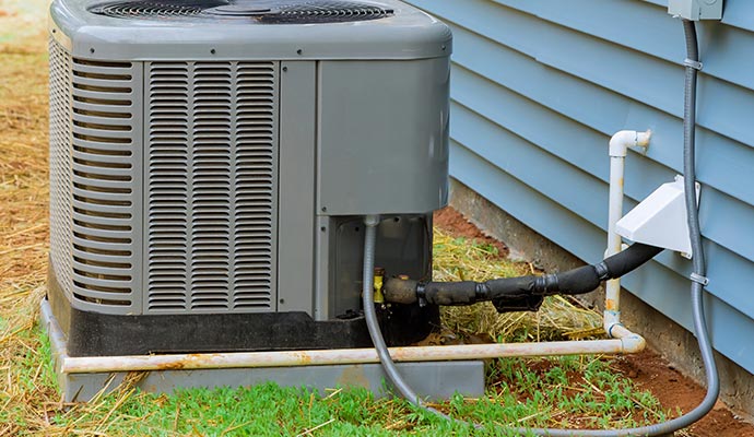 Outdoor air conditioning unit installed alongside a residential home