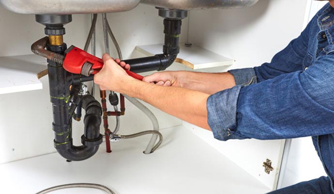 Plumbing work under sink in progress