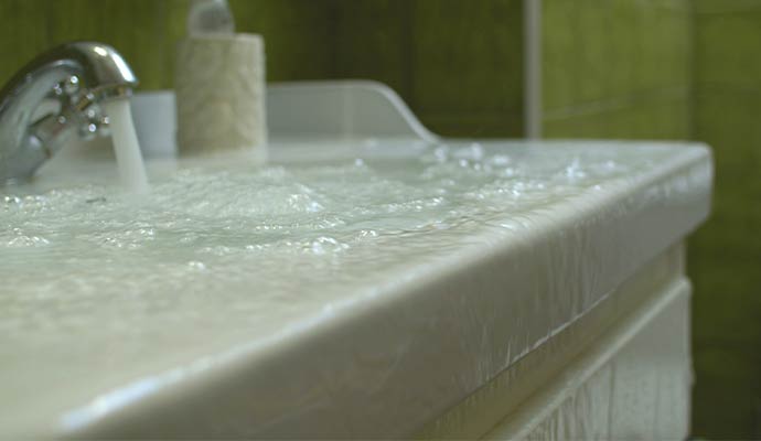 Water overflowing from clogged bathroom sink