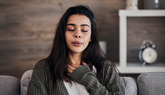 Woman experiencing breathing difficulty due to poor indoor air quality at home